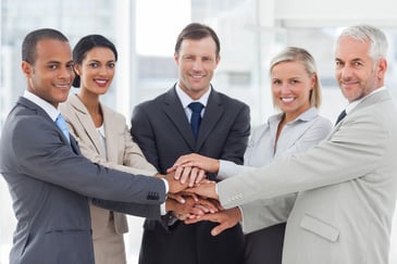 diverse group of men and women holding hands in an office setting